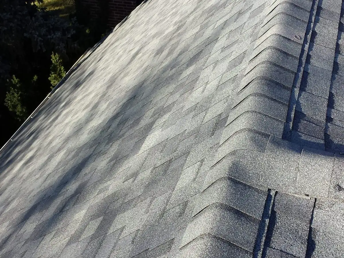 New ridge cap shingles running along the peak of the roof